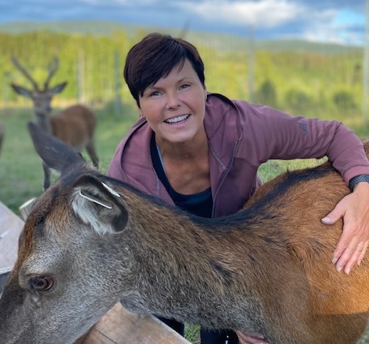 Mette Hågensen står og holder rundt en hjort