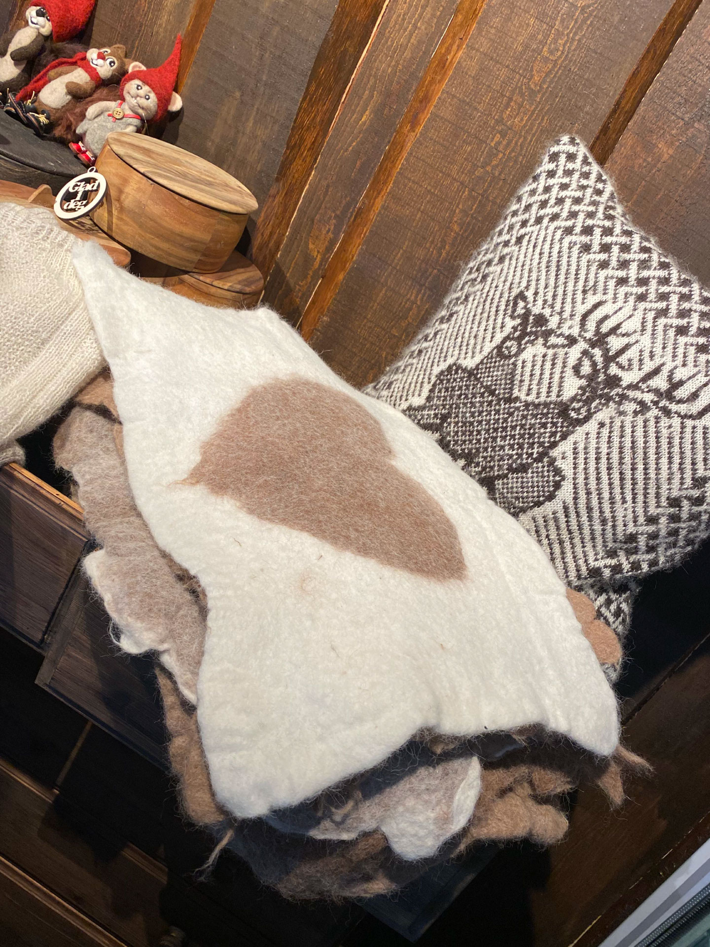 Pledd/liggeunderlag lagd av alpakkaull ligger til salgs i gårdsbutikken hos Eiker Hjort